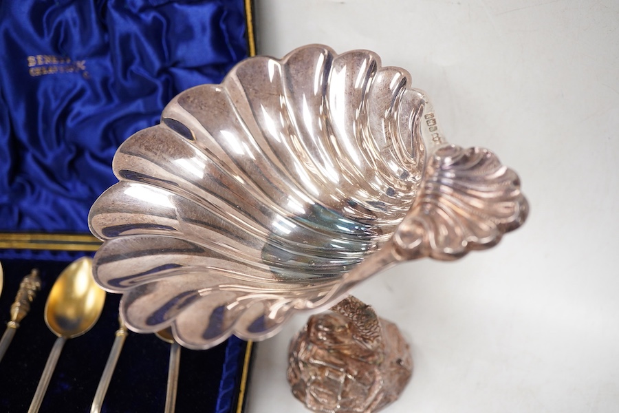 A modern silver shell dish on dolphin support, by Mappin & Webb, Sheffield, 1987, height 11cm, together with a cased set of six late Victorian parcel gilt silver apostle teaspoons, a 1960's small silver dish with Winston